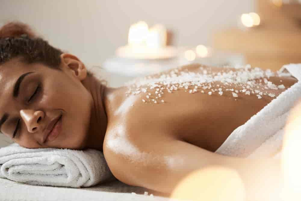 beautiful-african-woman-resting-relaxing-with-sea-salt-back-spa-salon-min